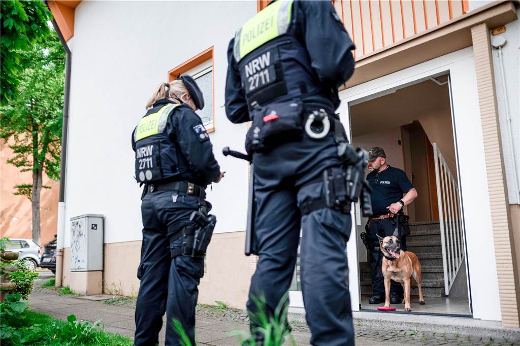 Anschlagsplan auf Essener Schule: Schüler nennt bekannte Massenmörder als Vorbild Ein Polizist mit Spürhund steht im Hauseingang des Tatverdächtigen in Essen.
