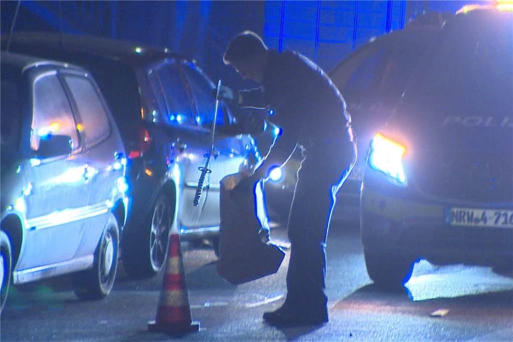 Gewalteskalation auf offener Straße: Drei Verletzte in Dortmund Ein Polizist sichert ein Beweisstück: Augenscheinlich eine Art Schwert.