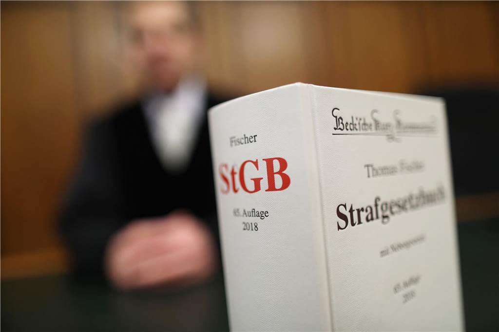 Tödlicher Unfall auf der Kurler Straße: „Das waren Sie“ Im Vordergrund ein Strafgesetzbuch, im Hintergrund ein Anwalt.