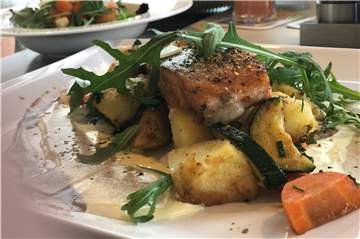 Ein purer Genuss: Das Lachsfilet vom Grill. Im Hintergrund ist die Salatbeilage auf einem Extra-Teller zu sehen.