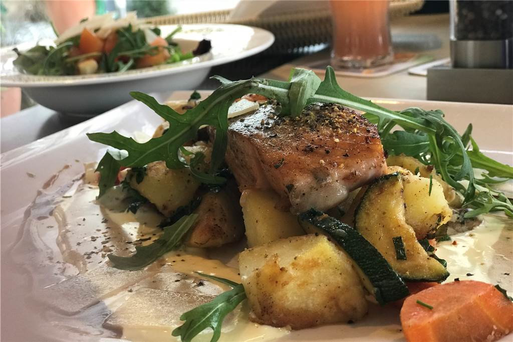 Das Panorama Café im Stadtgarten bietet mehr als nur Kaffee und Kuchen Ein purer Genuss: Das Lachsfilet vom Grill. Im Hintergrund ist die Salatbeilage auf einem Extra-Teller zu sehen.