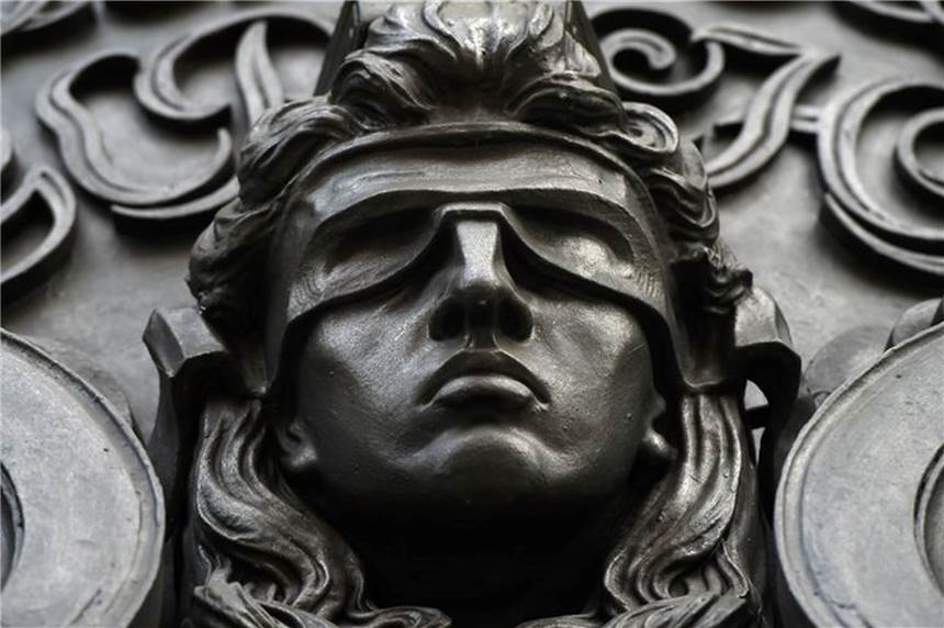 Kindesmissbrauch: Lehrer (30) zu Haftstrafe verurteilt Ein Relief zeigt das Haupt der Justitia mit verbundenen Augen.