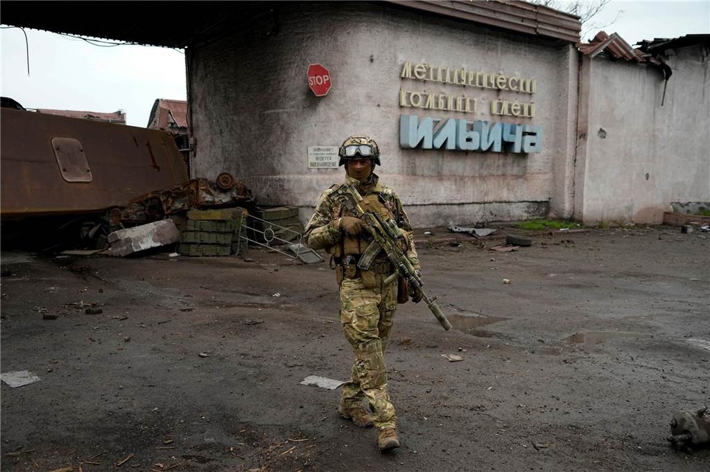 Ein russischer Soldat patrouilliert im Mai 2022 durch einen zerstörten Bereich des Iljitsch Eisen- und Stahlwerks Mariupol. Der russische Angriffskrieg geht bald in das dritte Jahr.