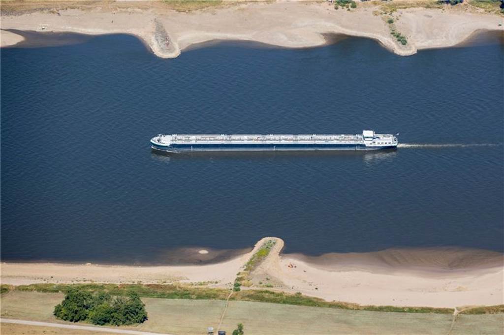 Wie der Klimawandel in Deutschland zu Niedrigwasser in Flüssen beiträgt Ein Schiff mit wenig Ladung fährt bei Köln bei niedrigem Wasserstand auf dem Rhein.