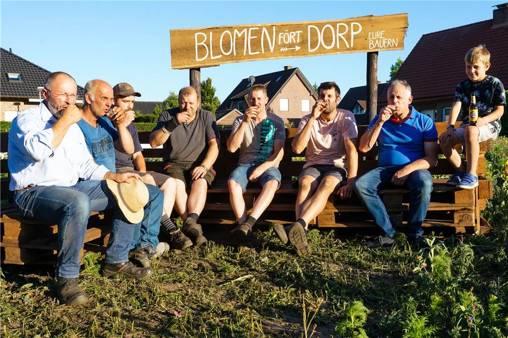 Mit Video: Blühwiese macht Insekten, Besuchern und dem Ferienlager Freude Ein Schnaps und auch ein zweiter nach getaner Arbeit - die Europalettenmöbel haben die Landwirte in Ellewick in die Blühwiese gestellt und genießen nun ihr Werk. Dazu sind auch alle Interessierten eingeladen, die sich gegen eine Spende auch etwas Blühendes für die Vase zuhause mitnehmen dürfen.