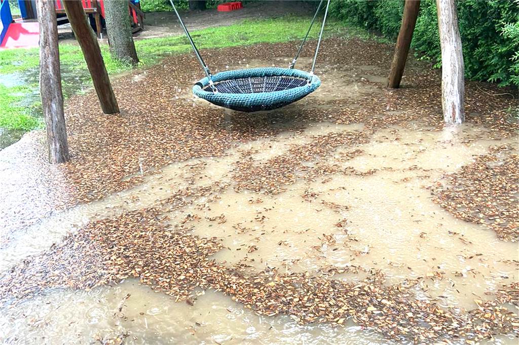 Ein See mit Holzschnipseln hat sich auf dem Spielplatz im Bereich der Schaukel gebildet.