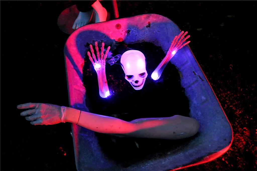 Am „Horrorhaus von Geisecke“ tanzten Vampire und Knochenmänner Ein Skelett leuchtet aus seinem Grab in der Schubkarre.