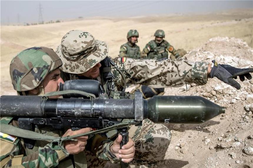 Mehr Soldaten nach Afghanistan und Mali Ein Soldat der Bundeswehr weist einen Angehörigen der kurdischen Peschmerga in einer Ausbildungseinrichtung nahe Erbil (Nordirak) ein. Foto: Michael Kappeler/Archiv