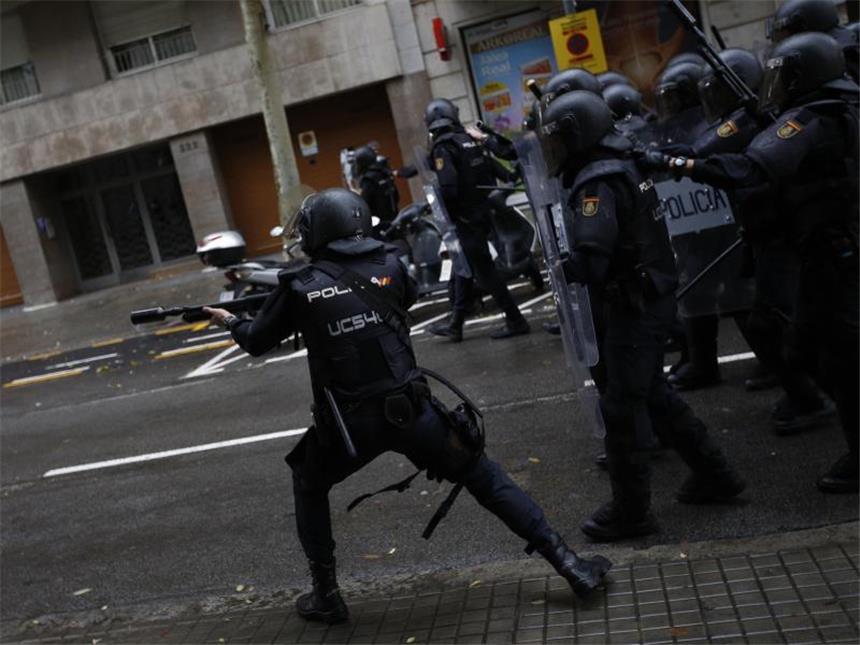 Hunderte Verletzte nach Gewalt bei Katalonien-Abstimmung Ein spanischer Polizist schießt mit Gummigeschossen auf Menschen, die in Barcelona zu einem Wahllokal wollen. Foto: Emilio Morenatti
