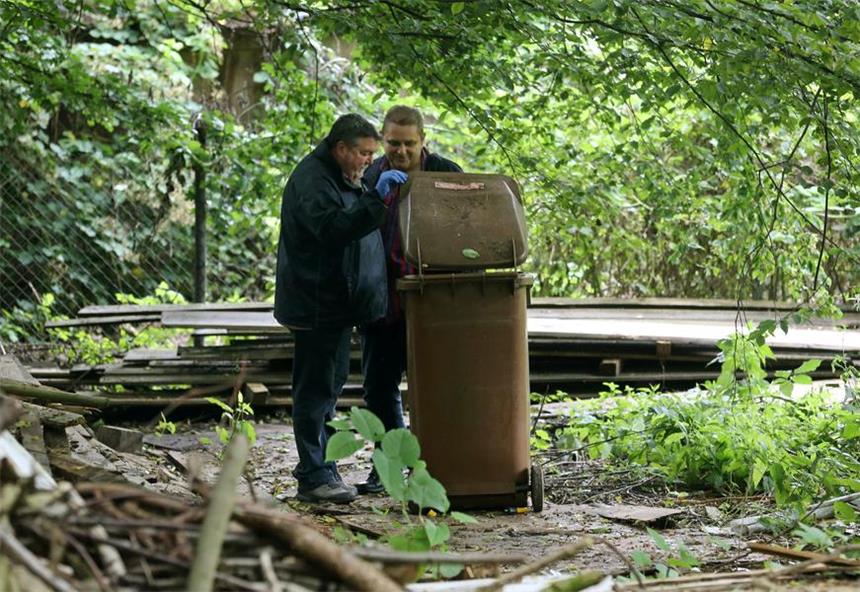 Ekelmüll-Serie: Ermittler kommen nicht voran Ein städtischer Bediensteter kontrolliert am 30.06.2016 auf dem Gelände in Essen die Umgebung. Im Hofgebäude sind Mülltonnen mit stinkendem Abfall entdeckt worden. Das Gewicht der Müllbehälter könne «in den Tonnenbereich gehen», sagte ein Polizeisprecher am Donnerstag.