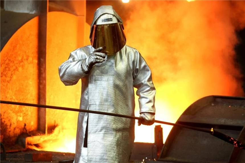 Ein Stahlarbeiter prüft am Hochofen 8 bei ThyssenKrupp die Stahlqualität nach dem Abstich. Foto: Roland Weihrauch/Archiv