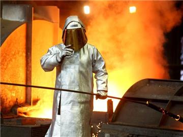 Ein Stahlarbeiter prüft an einem Hochofen bei ThyssenKrupp in Duisburg die Stahlqualität nach dem Abstich. Foto: Roland Weihrauch