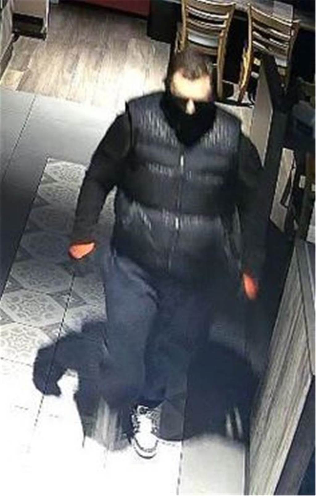 Wer brach in die Bäckerei-Filialen ein? Polizei sucht mit Bildern Ein Mann, kräftige Statur, dunkle Haare, schwarzer Pullover mit langen Ärmeln, darüber eine schwarz-gemusterte Steppweste, orange-schwarzfarbene Handschuhe, blaue Jogginghose und weiße Sneaker mit schwarzen Details an der Spitze und den Seiten