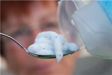 Ein Teelöffel mit einer Kosmetik, die Mikroplastik (blaue Perlen) enthält.