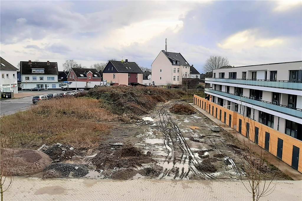 Wilde Spekulationen um 92 neue Sozialwohnungen in Dortmund: Warum zieht hier keiner ein? Ein Teil der Außenanlagen muss noch gepflastert und hergerichtet werden. Rechts im Bild sind die Holzkuben zu sehen, die als Kellerersatzräume dienen.