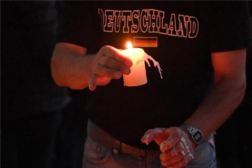 Hunderte Menschen bei Kundgebungen in Köthen und Halle Ein Teilnehmer einer Kundgebung für den verstorbenen 22-Jährigen legt auf einem Spielplatz in Köthen eine Kerze ab. Foto: Ralf Hirschberger