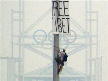 Ein Tibet-Aktivist hat ein Transparent an einem Mast befestigt.
