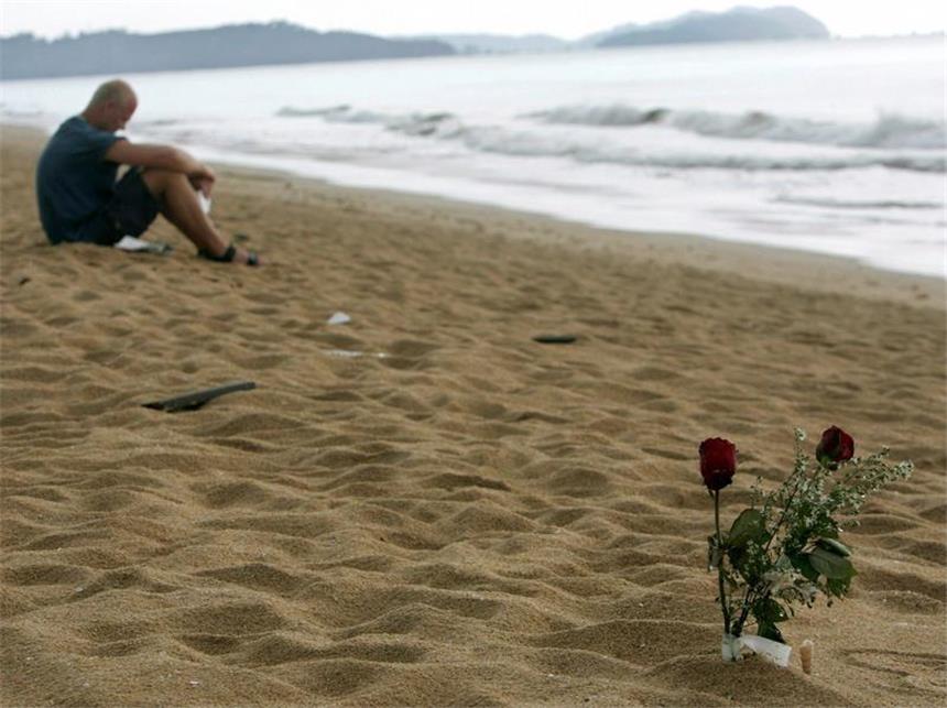Thailand und Indonesien gedenken der Tsunami-Opfer Ein trauernder Überlebender sitzt am ersten Jahrestag der Tsunami-Katastrophe am Strand von Khao Lak in Thailand. Foto: Rungroj Yongrit