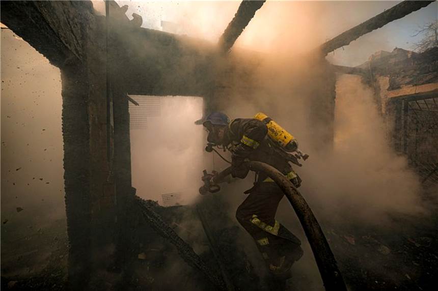 Krieg gegen die Ukraine: So ist die Lage am Mittag Ein ukrainischer Feuerwehrmann bei Löscharbeiten in einem nach russischen Angriffen zerstörten Haus in Kiew.