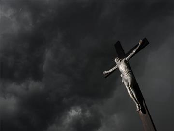 Ein Wegekreuz vor dunklen Gewitterwolken. Foto: Felix Kästle/Illustration