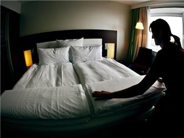Ein Zimmermädchen macht in einem Kölner Hotel das Bett in einem der Zimmer. Foto: Oliver Berg/Archiv