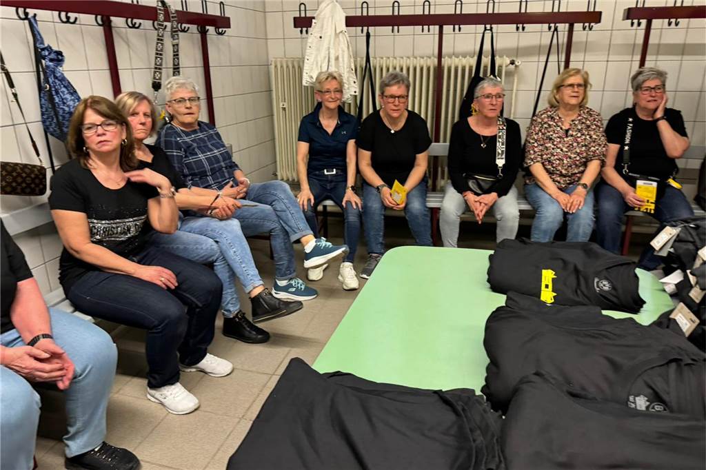 Frauen sitzen auf Bänken in einer Kabine