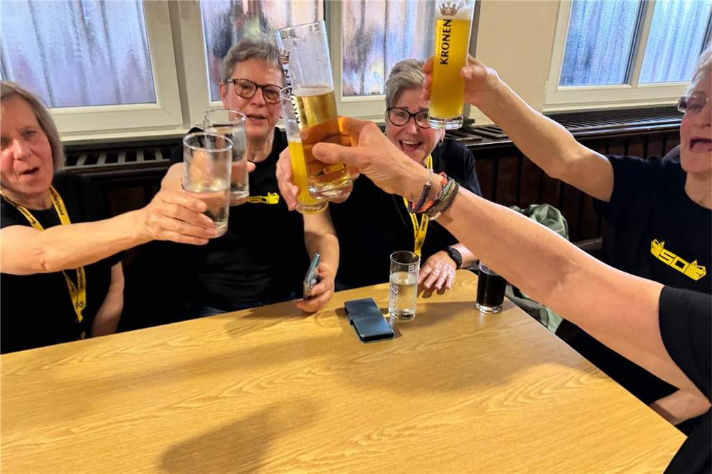 Frauen sitzen an einem Tisch und prosten sich zu