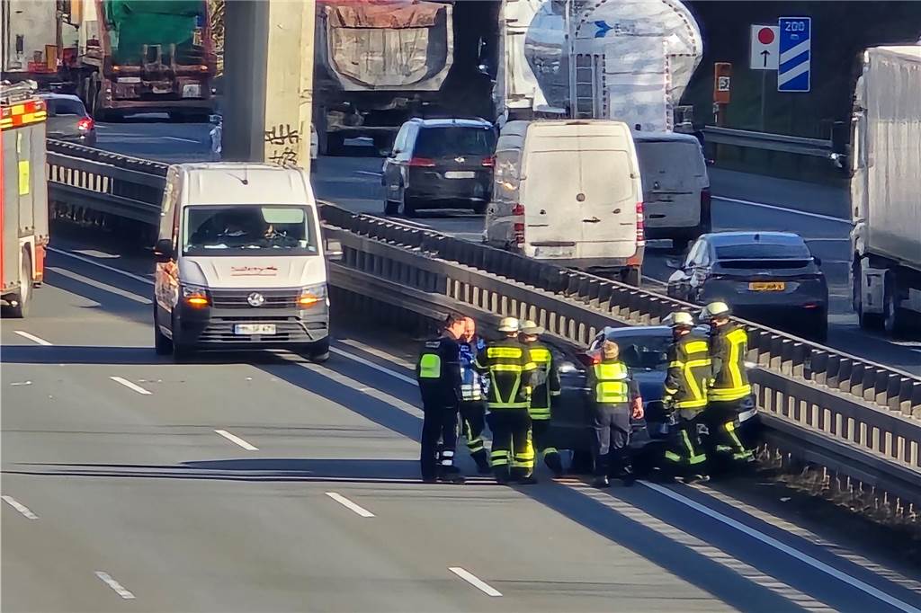 Feuerwehrkräfte stehen nach dem Unfall auf der A2 bei Dortmund vor einem der beteiligten Fahrzeuge.