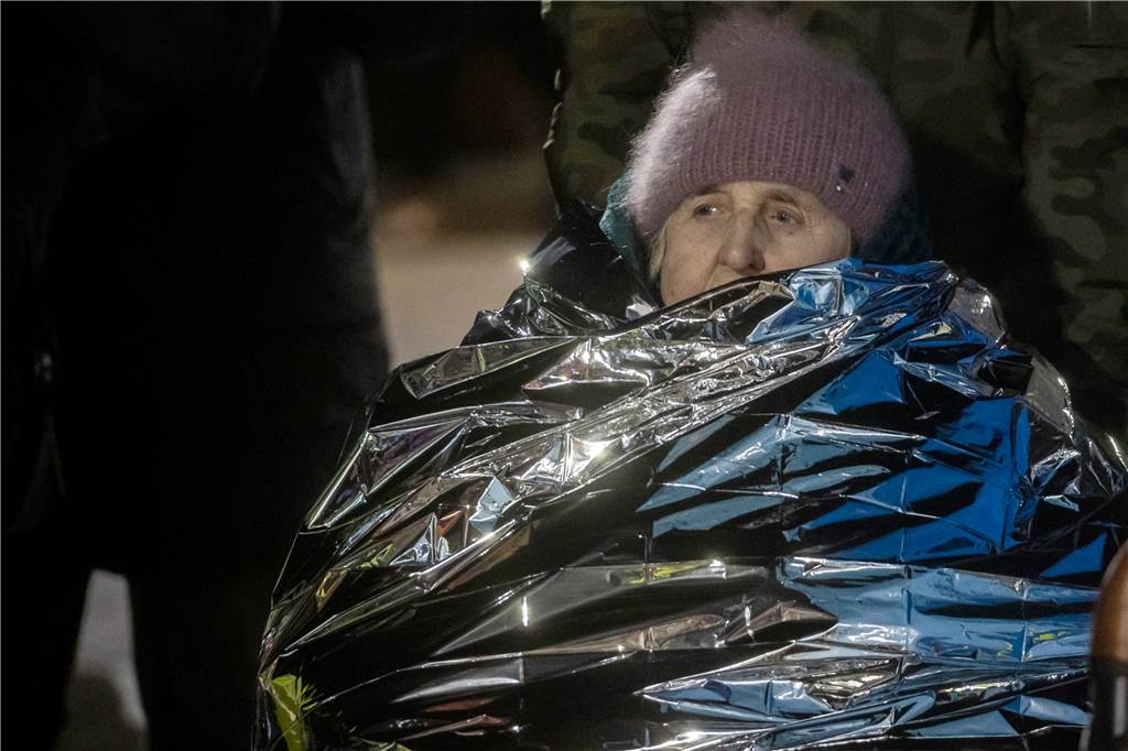 Eine alte Dame aus der Ukraine sitzt in einem Rollstuhl, eingewickelt in eine Wärmefolie Rettungsfolie gegen die frostigen Temperaturen am Grenzübergang Medyka in Polen. Weiterhin strömen jeden Tag tausende Menschen aus der Ukraine in den Westen. 