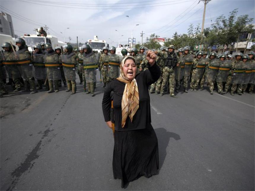 31 Tote bei Anschlag in Chinas Unruheregion Xinjiang Eine Angehörige der uigurischen Minderheit demonstriert vor einer Reihe von Polizisten in Ürümqi. Foto: Diego Azubel/Azubel