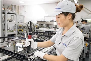 Eine Arbeiterin im Schanghai-Werk des deutschen Autozulieferers Webasto bei der Produktion eines Autodachs. Foto: Webasto Group