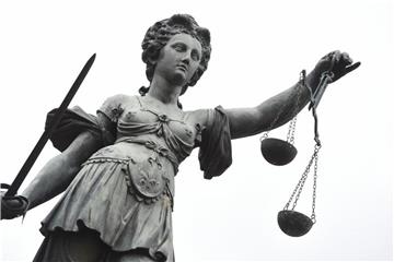 Eine Bronzestatue der Justitia steht in Frankfurt am Main. Foto: Arne Dedert/Archiv