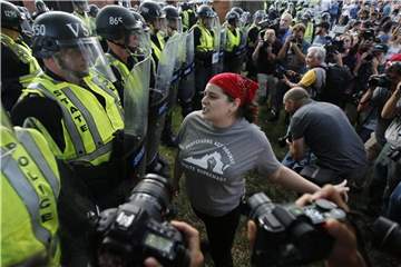 Eine Demonstrantin und Polizisten während einer Demonstration auf dem Campus der Universität von Virginia in Charlottesville. Foto: Steve Helber/AP