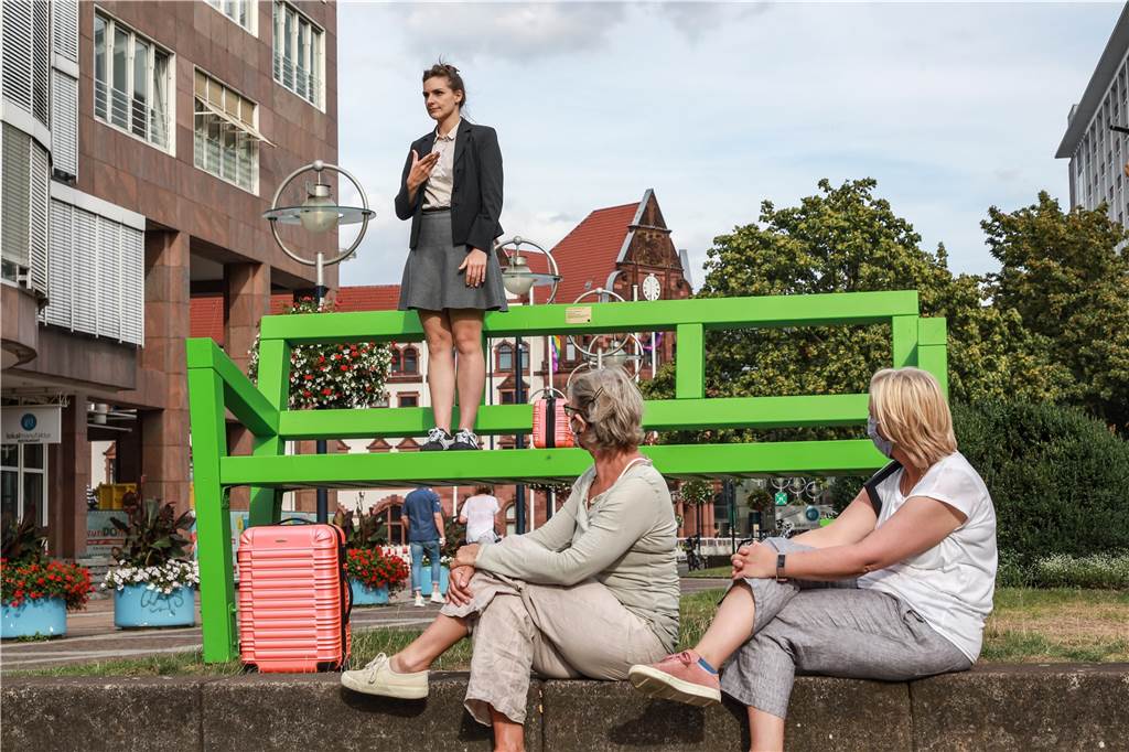 Tanz-Performance am Stadtgarten irritiert und verblüfft Dortmunder Eine der elf Stationen war die große, grüne Bank. Auf dieser stellte die Performerin Pia Alena Wagner die Fragen nach Heimat und Zuhause.