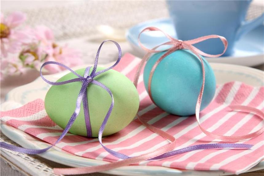 Mit Liebe zum Detail: Ideen für die Oster-Dekoration Eine einfache, aber wirkungsvolle Idee für die Teller der Gäste zum Osterfrühstück: Heitmann Deco zieht ein Band mit einer Schleife um gefärbte Eier. Foto: Heitmann Deco/dpa-tmn