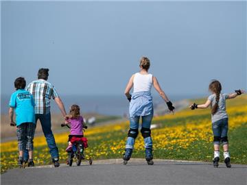 Eine Familie ist mit Inline-Skates, Fahrrad und Tretroller unterwegs. Foto: Matthias Balk