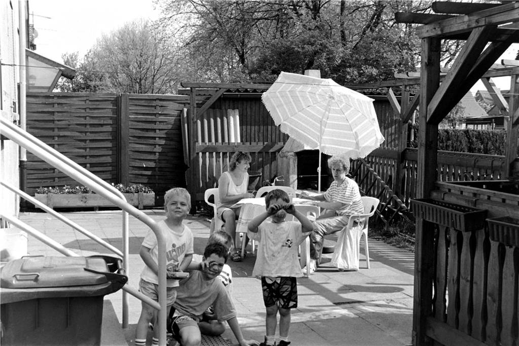 Eine Familie sitzt draußen in der Siedlung in Horstmar.