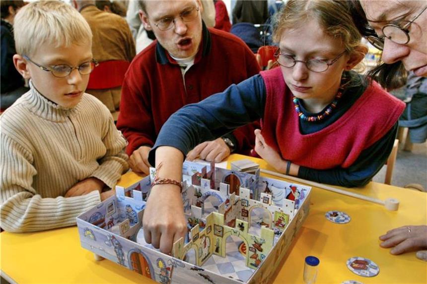 Essener Spielemesse startet mit Ausstellerrekord Eine Familie spielt auf der Essener Spielemesse mit einem Brettspiel. Foto: R. Weihrauch/Archiv