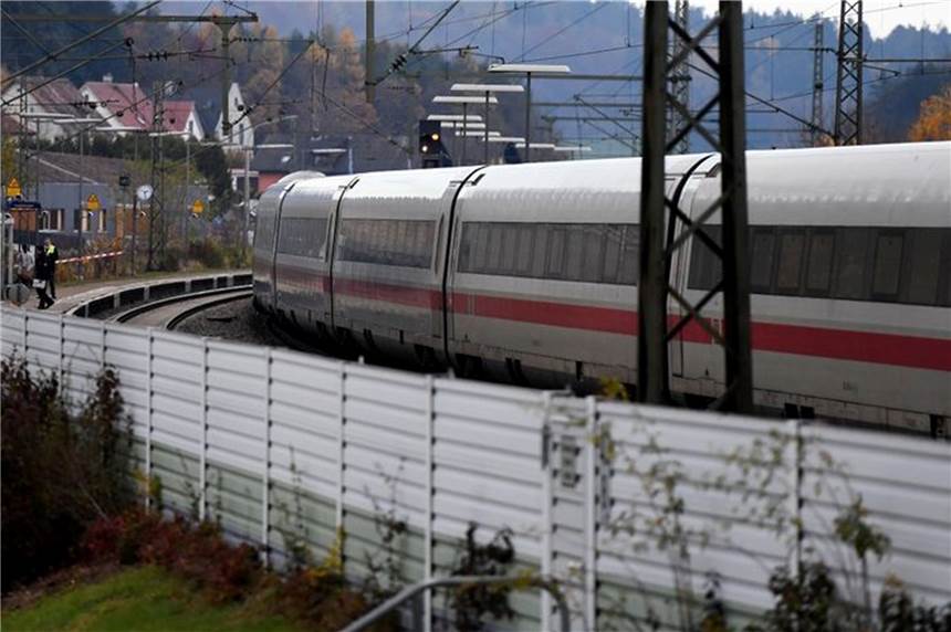 „Rennt nach hinten zum Zugende!“ - Messerattacke in ICE Eine festgenommene männliche Person wird nach einer Messerattacke am Bahnhof von Polizei und Rettungskräften weggeführt.