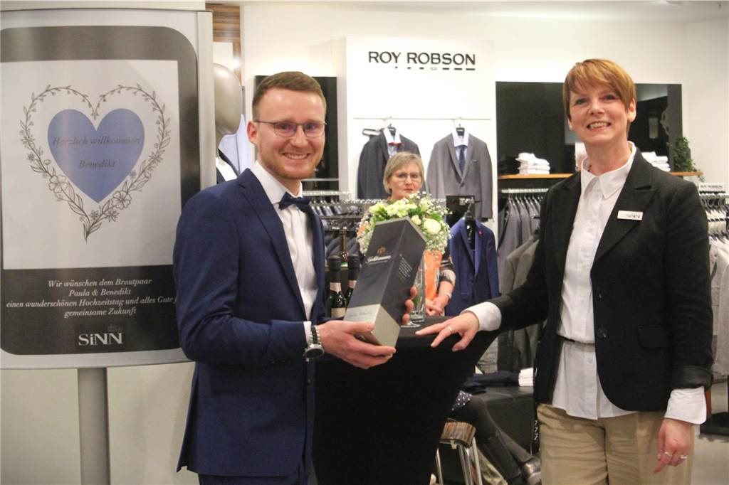 Zeitlose Eleganz: Benedikt Gertz kleidet sich im Modehaus Sinn ein Eine Flasche Sekt für den Gewinner der Traumhochzeit 2023, überreicht von Store-Managerin Sandra Rux.