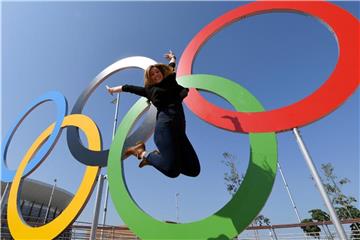 Eine Frau 2016 vor den Olympischen Ringen in Rio de Janeiro. Foto: Felix Kästle/Archiv