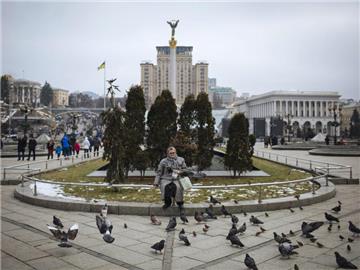 Eine Frau füttert Tauben auf dem geschichtsträchtigen Maidan. Foto: Roman Pilipey