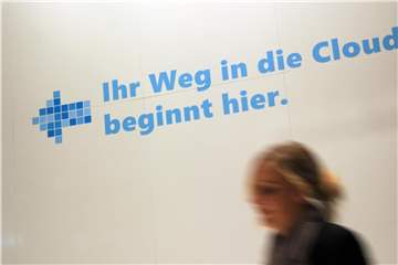 Eine Frau geht an einem Werbeslogan der Firma Microsoft zum Cloud Computing auf dem Messegelände in Hannover vorbei. Foto: Caroline Seidel