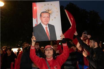 Eine Frau hält bei einer Siegesfeier auf dem Kurfürstendamm in Berlin ein Erdogan-Porträt. Foto: Paul Zinken