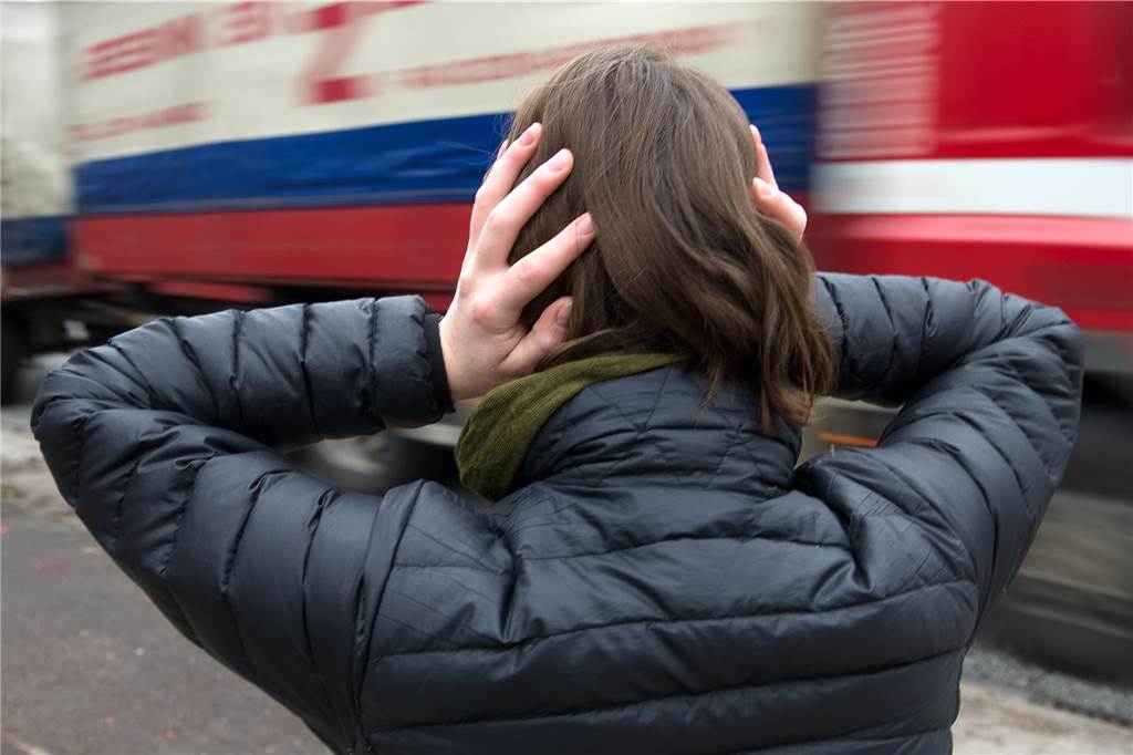 Tempo 30 wegen Lärmschutz in Dortmund: Wird es dann tatsächlich leiser? Eine Frau hält sich vor einem nahenden Lastwagen die Ohren zu. (Symbolbild)