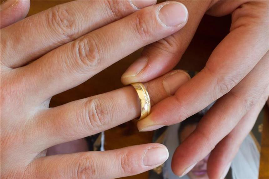 Eine Frau nimmt ihren Ehering ab. Foto: Patrick Pleul/Symbolbild