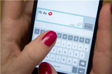 Eine Frau tippt auf einem Smartphone. Foto: Sebastian Gollnow/Illustration