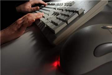 Eine Frau tippt auf einer Computertastatur. Foto: Jochen Lübke/Illustration