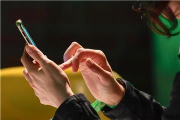 Eine Frau tippt auf ihrem Smartphone. Foto: Jens Kalaene/Archiv