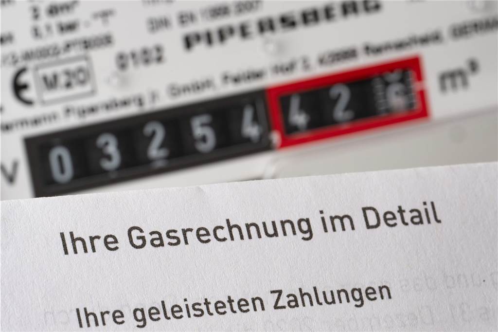 Gasheizung kaufen: Lohnt sich das jetzt überhaupt noch? Eine Gasrechnung wird in einem privaten Haushalt vor einem Gaszähler gehalten (gestellte Szene).